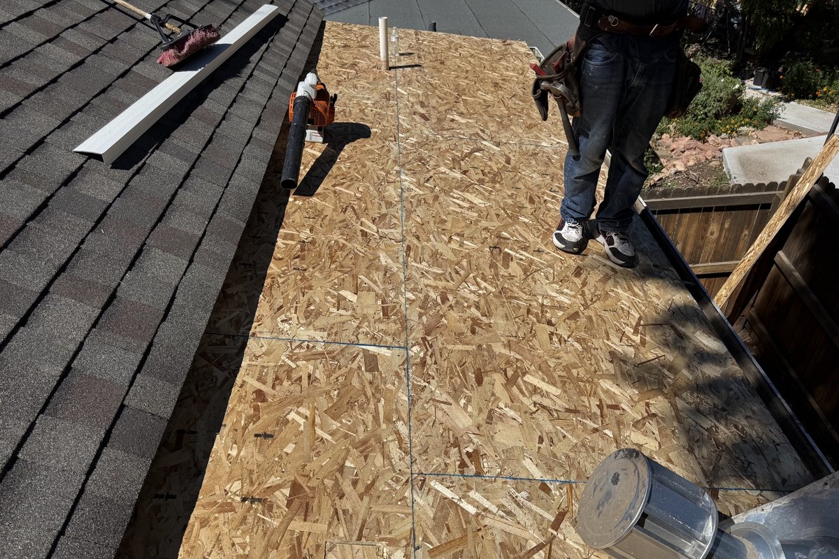 Roofers replacing damaged roofing over exposed roof decking