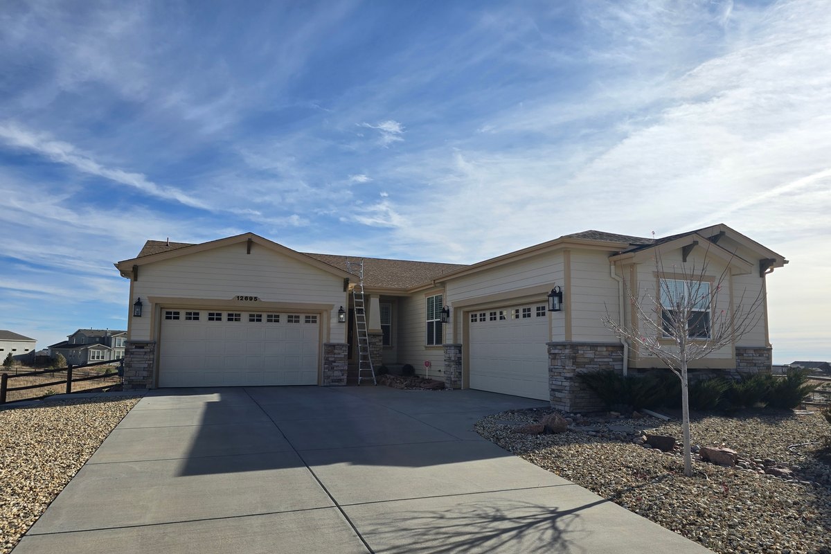Single-story house with gutter runs above a wide driveway