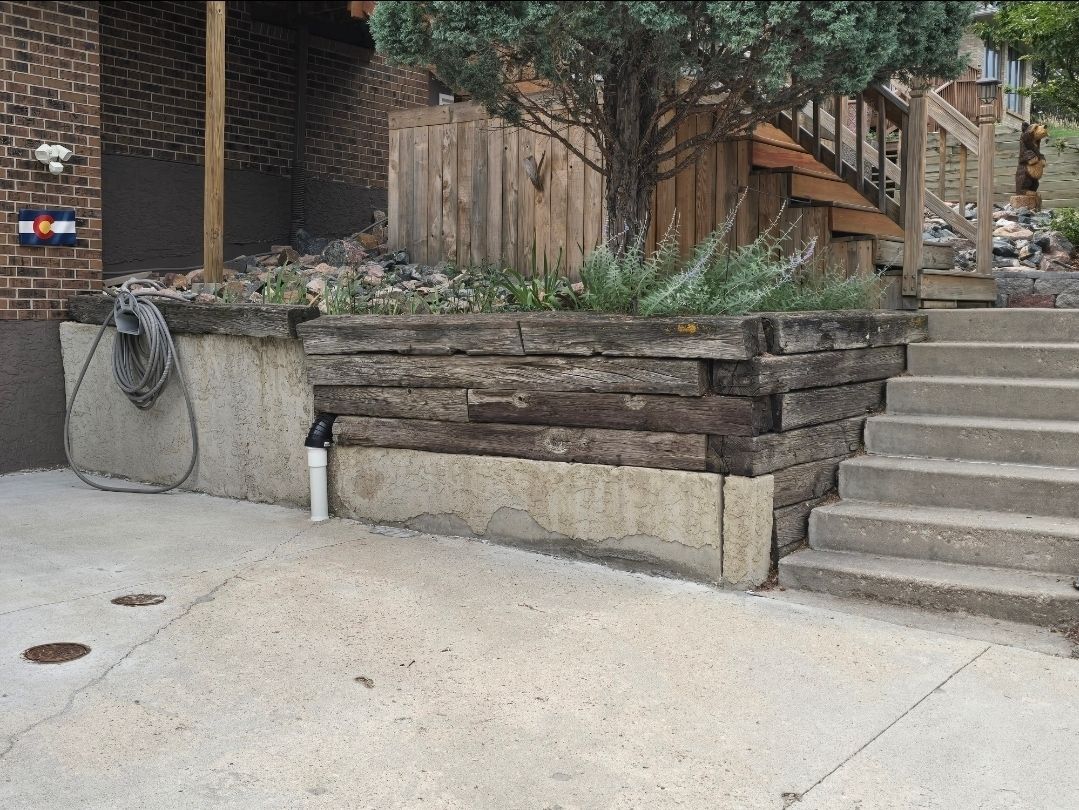 Aged timber retaining wall and concrete steps before reconstruction