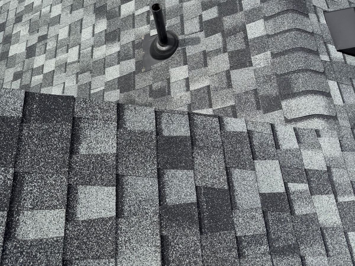 Gray and black architectural shingles around a pipe vent on a finished roof