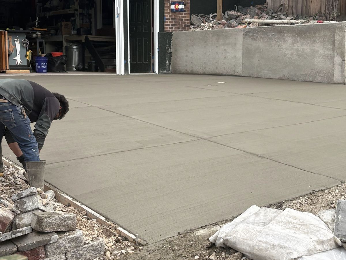 Worker floating the surface of a freshly poured concrete slab