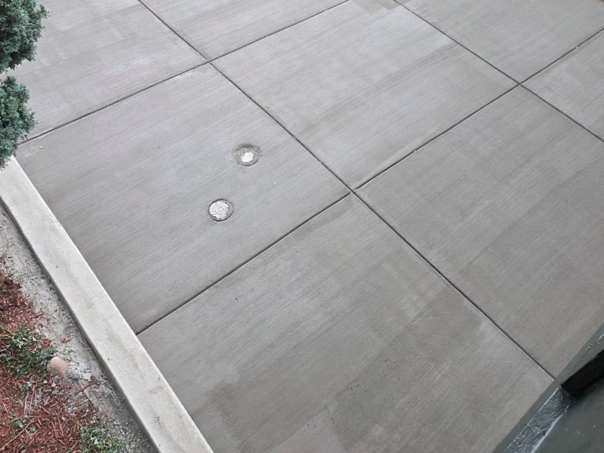 Concrete surface with intersecting joints and two round covers