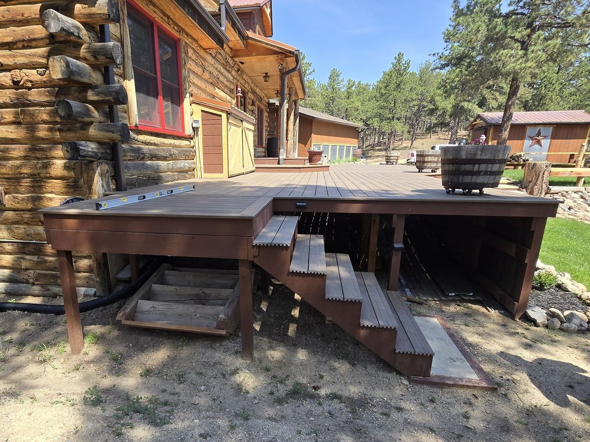 Log home with a rebuilt deck and stained timber stairs down to the yard