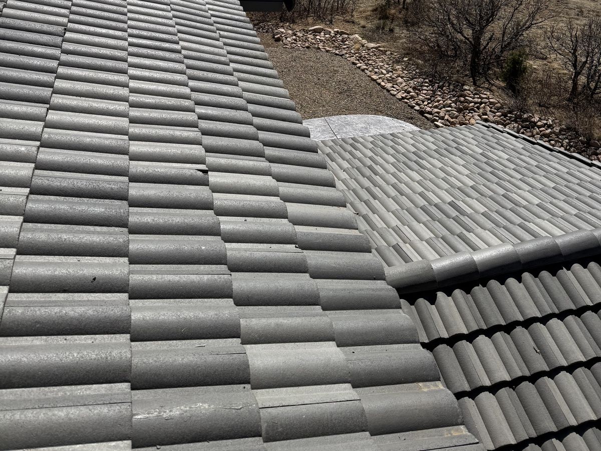 Intersecting tile roof surfaces with a strip of ground beyond