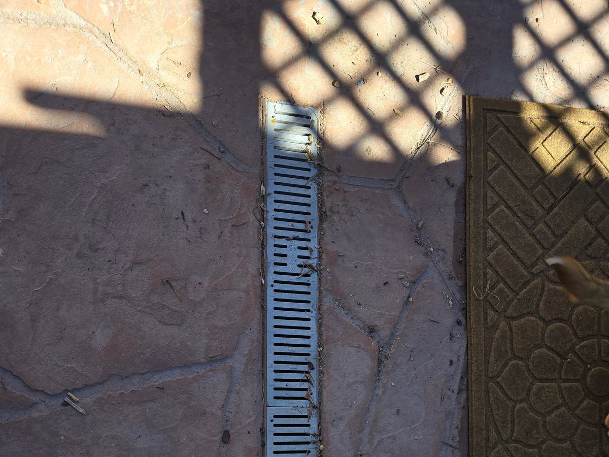 Decorative concrete with a stone pattern running to a drain channel