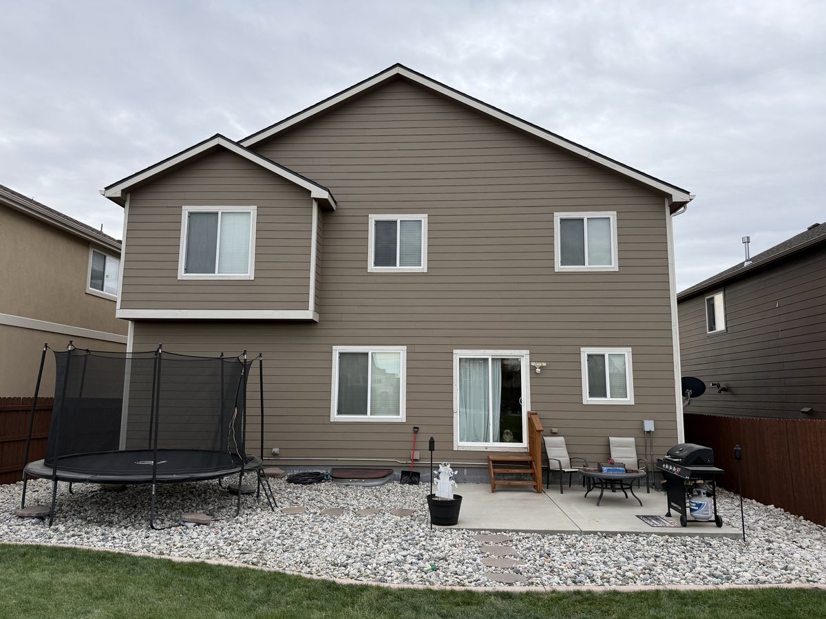 Two-story house with finished siding across the rear elevation