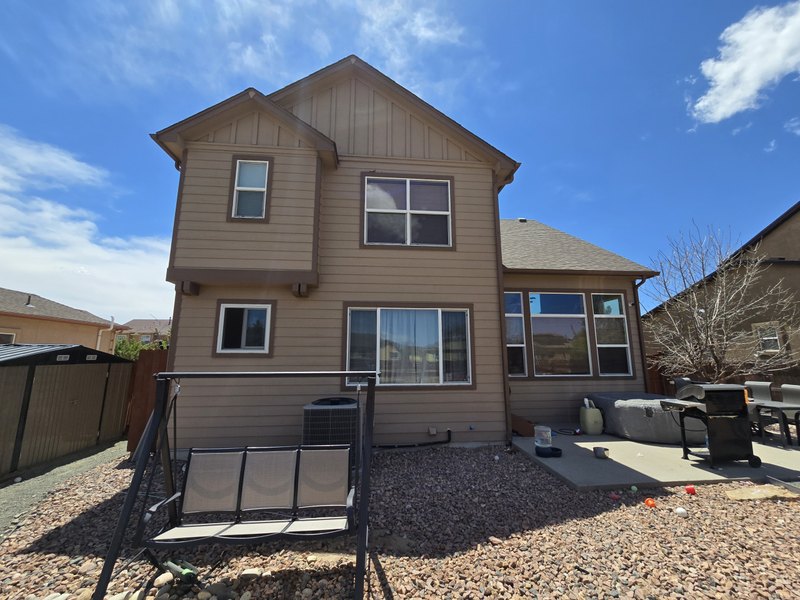 Two-story house with finished exterior siding, gutters, and downspouts