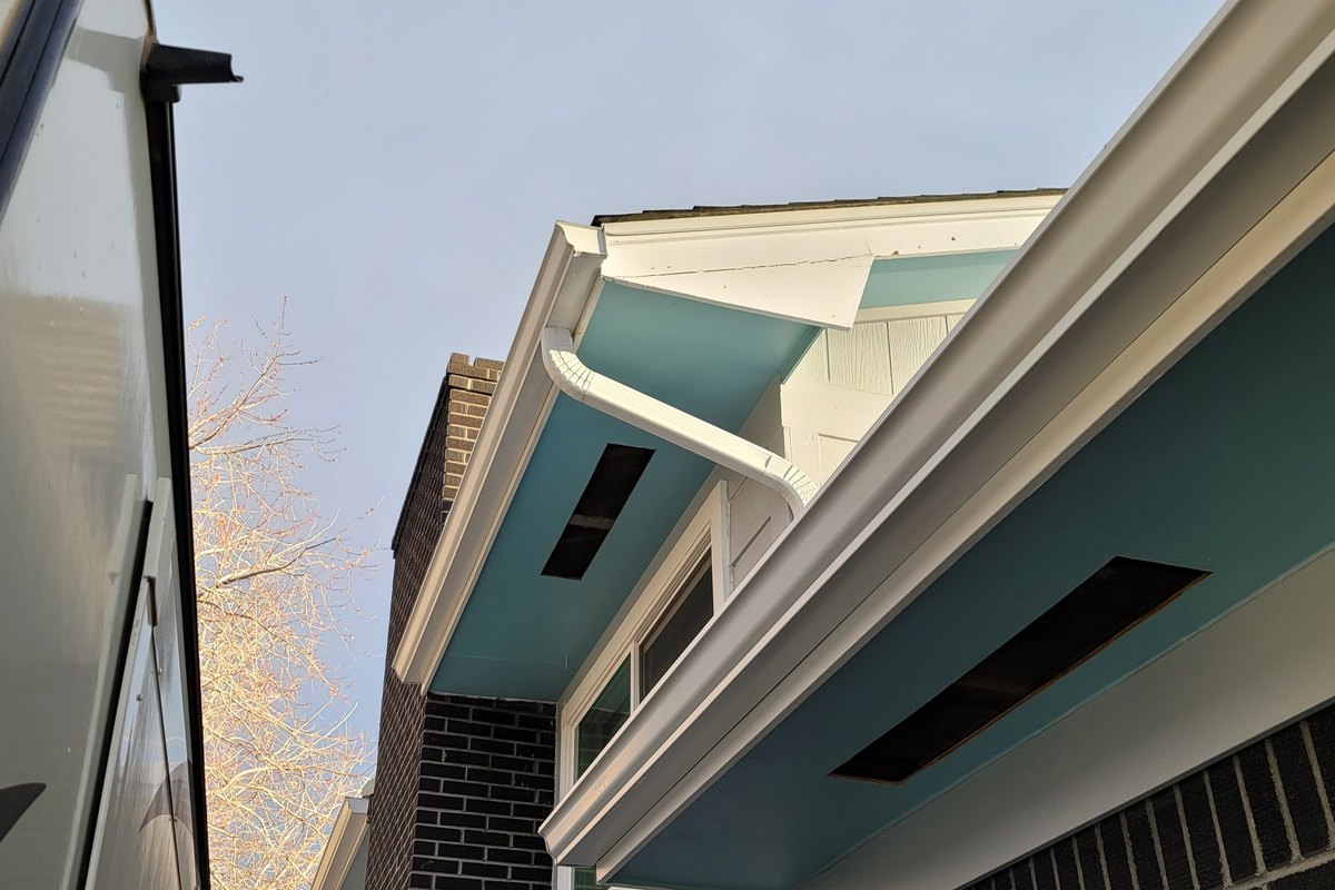 New gutter and downspout running along the eave of a modern house