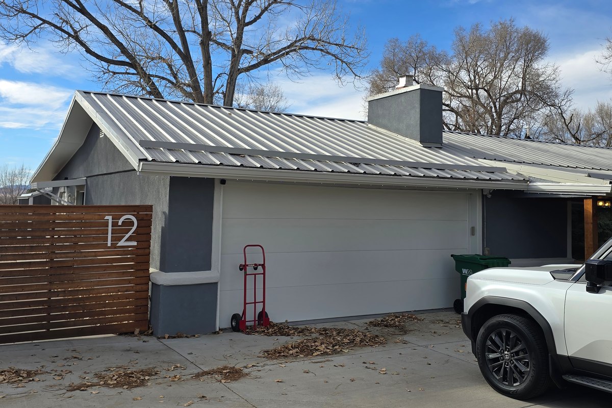 House with a metal roof running down to the garage below it