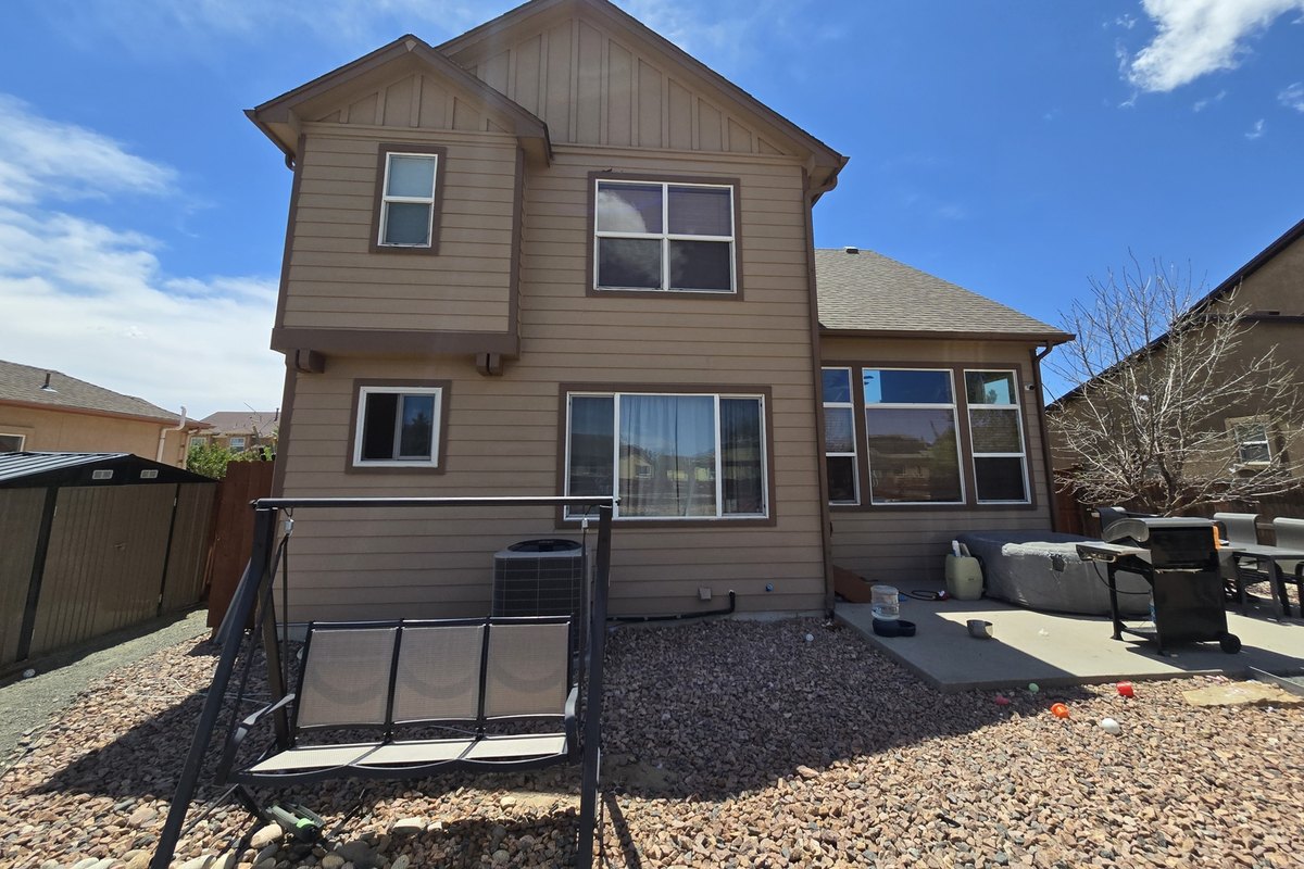 Two-story house with gutters and downspouts along the rear eaves