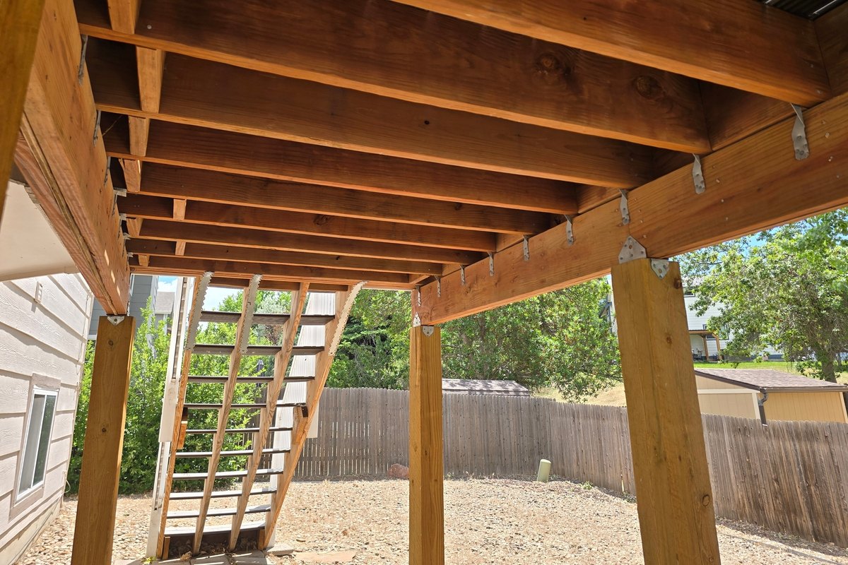 Deck framing from below, with the joists, beams, and posts exposed