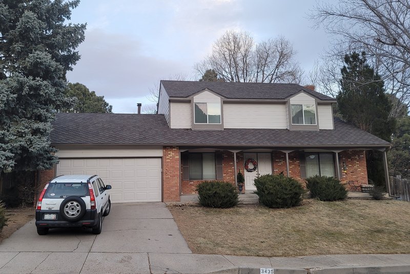 Two-story house with brick and painted siding after an exterior repaint