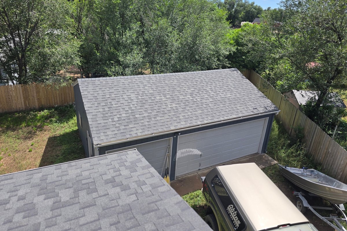 Sound gray shingle roof above a garage with clear flashing details