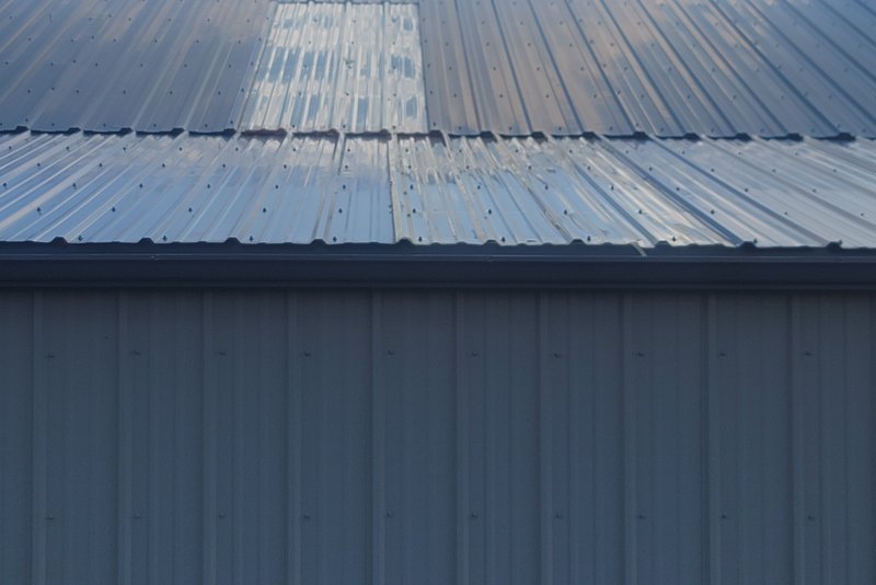 Ribbed metal roof panels with exposed fasteners and a horizontal overlap